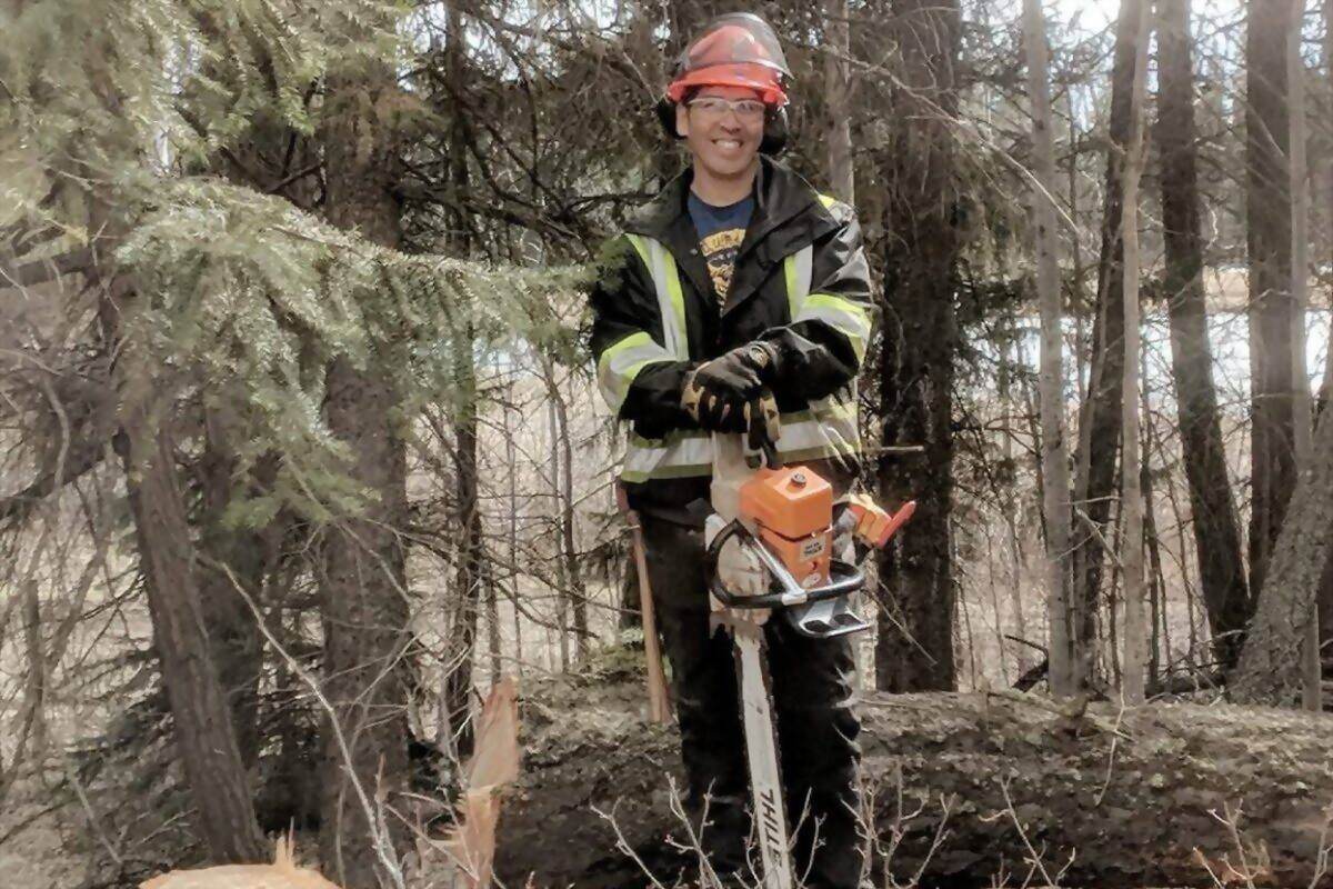 Working in burned timber near 100 Mile House with a chainsaw and full protective gear